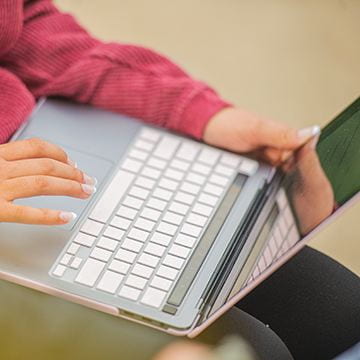 Close-up of student using their laptop. 